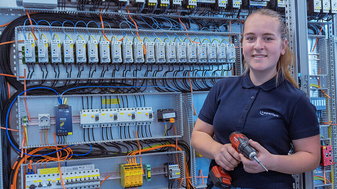 Coperion mechatronics egineer with tools in front of control cabinet