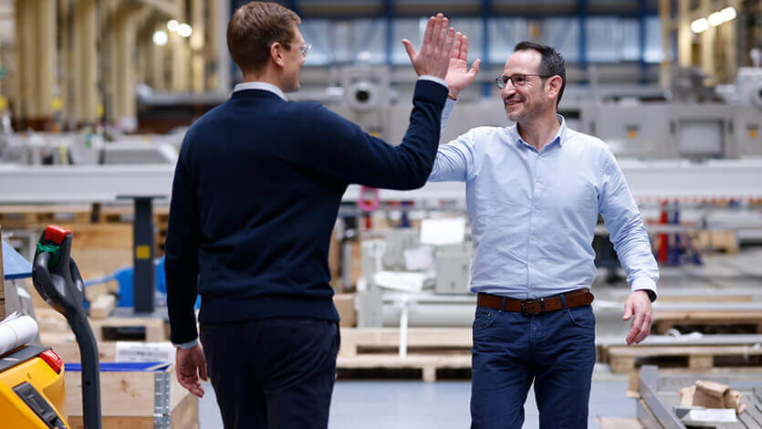 Coperion Mitarbeiter grüßen sich in der Montagehalle