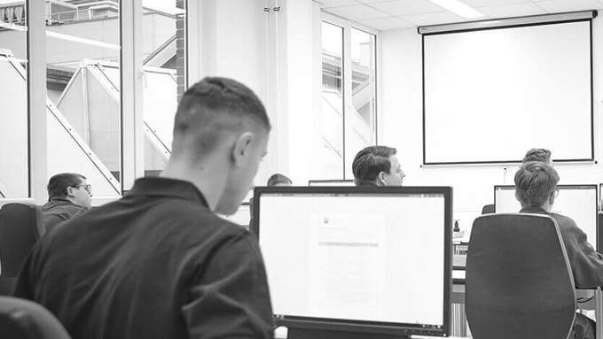 Student arbeitet am Computer während Vorlesung schwarz und weiß