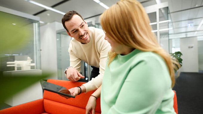 Coperion employees talking on a sofa with ipad in hands